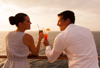 romantic young couple toasting with cocktail on cruise ship; Shutterstock ID 235800823; other: -; purchase_order: -; client: -; job: -