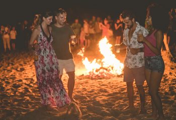 Happy friends drinking beer at beach music festival - Young people having fun summer vacation - Youth lifestyle, holidays and party concept - Soft focus on afro girl face; Shutterstock ID 1444302359; other: -; purchase_order: -; client: -; job: -