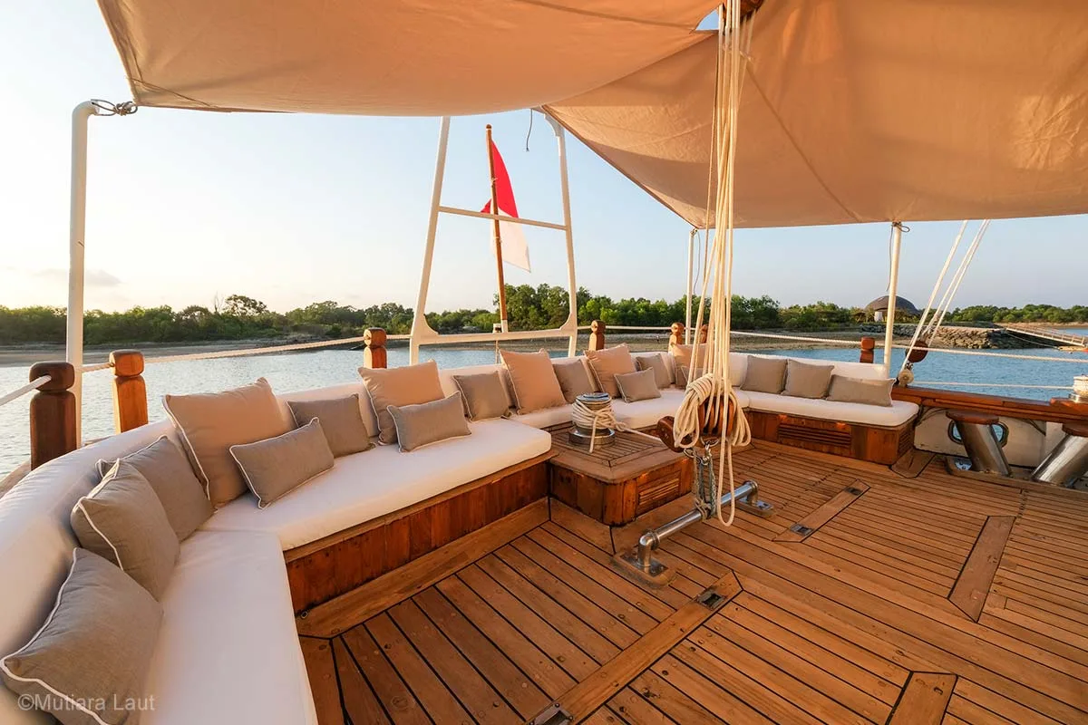 An aft deck with a large U shape seating lounge under a white cream canopy. Mutiara Laut. Mutiara Laut Liveaboard. Liveaboard Indonesia. Luxury liveaboard Indonesia. Luxury liveaboard Raja Ampat. Luxury liveaboard Komodo. Diving expeditions Indonesia. Indonesia Diving trip. Private liveaboard trip Indonesia. Luxury holidays Indonesia. Luxury Cruise Indonesia. Bespoke cruise Indonesia. Yacht charter Indonesia. Yacht charter Komodo. Yacht charter Raja Ampat. Private cruise Indonesia. Sailing trip Indonesia. Yacht Rental in Indonesia. Bespoke Indonesia Holiday.