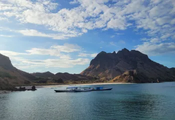 There are two small boats anchoring by an island with steep hillsides covered in dry savanna and encompassed by white sand beach. Padar Island. Komodo Island National Park. Sailing Destinations in Indonesia. Top Sailing Destinations in Indonesia. Komodo Liveaboard. Liveaboard Indonesia. Private Cruise Komodo. Bespoke Indonesia Holiday.